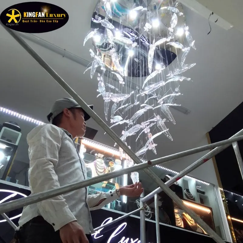 Thợ lắp đèn chùm thực hiện khoan gia cố ty treo xuyên qua lớp trần thạch cao